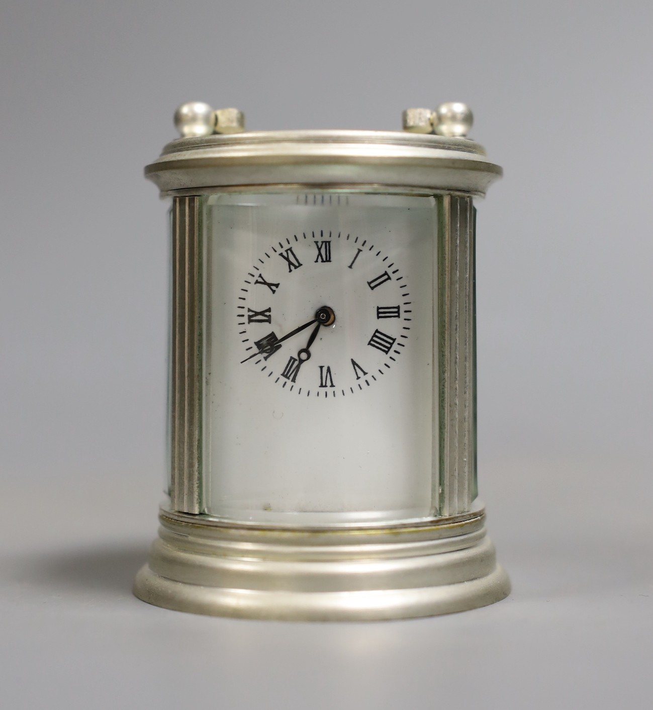 A circular plated carriage clock with key and a Victoria Cross gent's wristwatch